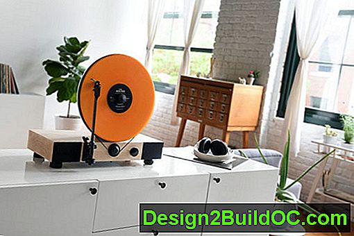 Disco giratorio tocadiscos vertical sentado en una sala de estar con una naranja, tocando el registro en posición vertical
