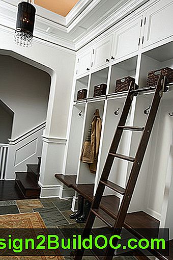 rjave klopi in rjavkasta lestevna knjižnica dajejo funkcionalni poudarek tej sobi s belim blatom z vgrajenimi omarami in omarami. Na hrbtni strani je vidno stopnišče