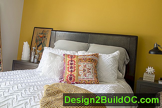 soveværelse med hvide sengetøj, indian-print pude og vægmalet honninggult