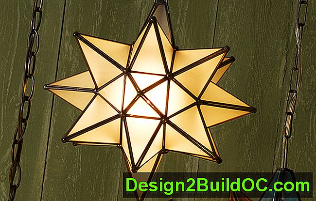 La luce pendente di una stella moraviana in vetro bianco traslucido era appesa a un muro di stecche di legno verde e dall'aspetto alterato