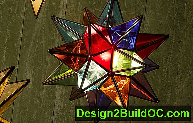 una lampada a sospensione con la stella moraviana in vetro dai colori vivaci era appesa a un muro di stecche di legno verde, simile ad una parete di legno