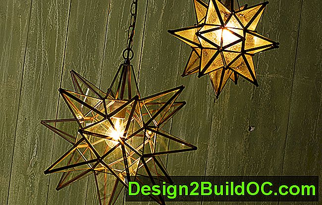 due luci a sospensione con stella morava accese, morbidamente accese, appese a un muro di stecca di legno dall'aspetto verde