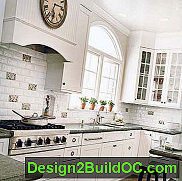 Kuhinja s bijelim obloženim staklenim prednjim ormarićima, nagibima beadboarda i bijelim svjetiljkama daje vintage izgled