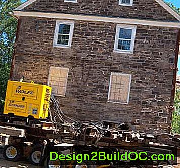 На левој страни је систем за дизање који држи ниво куће, а испод куће су челичне греде и колуте које ће одвести кућу у свој нови дом.